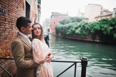 Doğadaki düğün çifti birbirine sarılıyor. Beyaz elbiseli güzel bir kız. Takım elbiseli adam.