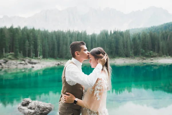 美丽的新婚夫妇在高山湖畔亲吻 — 图库照片