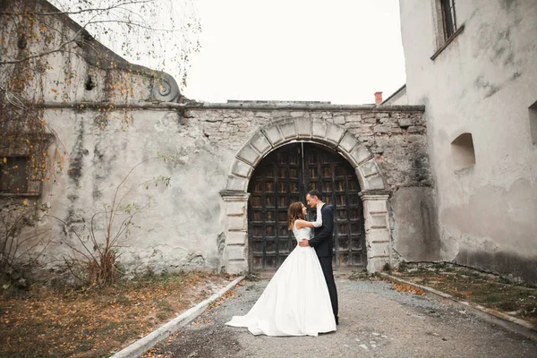美しい花嫁と新郎の抱擁とキスで彼らの結婚式の日屋外 — ストック写真