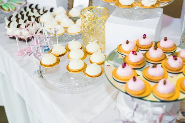 Delicious sweets on wedding candy buffet with desserts, cupcakes.
