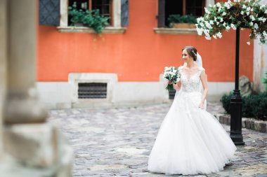 Gelin çiçekli büyük ve güzel bir düğün buketi tutuyor..