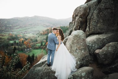 Dağların arka planında sevgi dolu bir koca ve kadın. Sevgili çift duygusal olarak vakit geçirir..