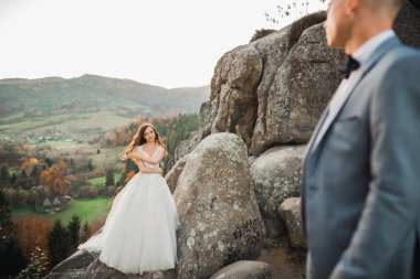 Dağların arka planında sevgi dolu bir koca ve kadın. Sevgili çift duygusal olarak vakit geçirir..
