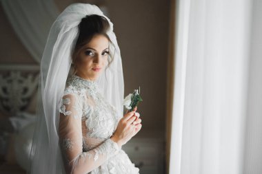 Gelin çiçekli büyük ve güzel bir düğün buketi tutuyor..