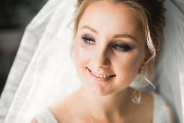 Beyaz elbiseli lüks gelin düğün törenine hazırlanırken poz veriyor..