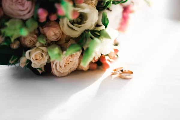 在一束鲜花的衬托下 有结婚戒指的美丽色调的照片 — 图库照片