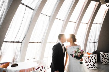 Güzel gelin ve damat düğün günlerinde kucaklaşıp öpüşürler..