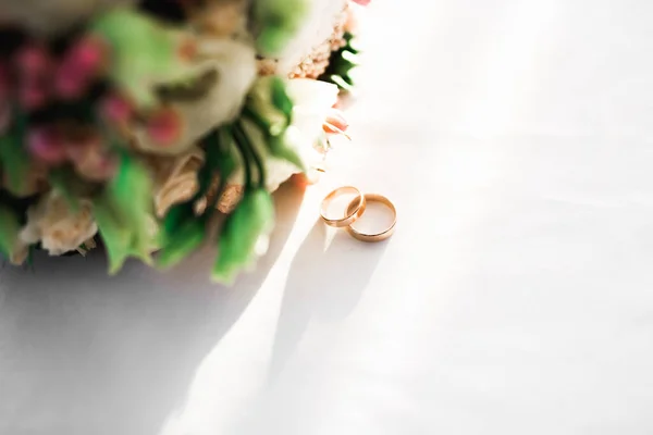 花の花束を背景に結婚指輪と美しいトーン絵 — ストック写真