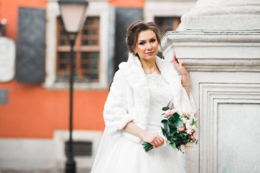 Gelinin güzel portresi moda gelinliği içinde tüylü, lüks makyaj ve saç stili..