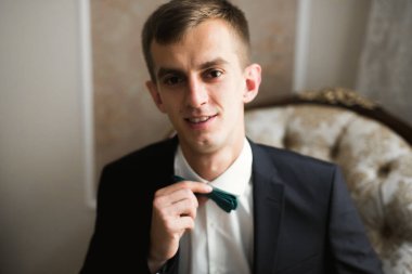 Güzel adam, damat poz veriyor ve düğüne hazırlanıyor..