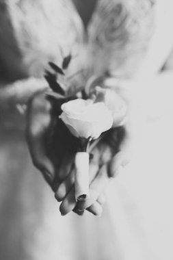 Zarif beyaz elbiseli güzel gelin elinde bir buket çiçek tutuyor..