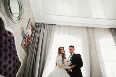 Güzel, genç bir çift ellerinde çiçeklerle poz veriyorlar..