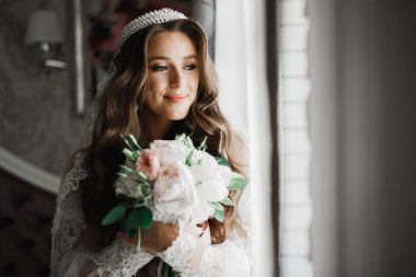 Çekici gelinin portresi, uzun saçlı, büyük buketli poz veren..