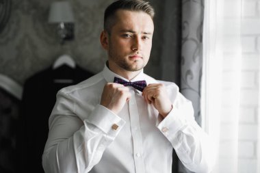 Güzel adam, damat poz veriyor ve düğüne hazırlanıyor..