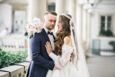 Güzel, genç bir çift ellerinde çiçeklerle poz veriyorlar..