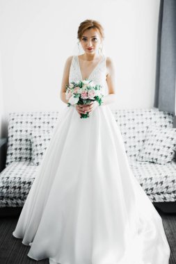 Gelin çiçekli büyük ve güzel bir düğün buketi tutuyor..