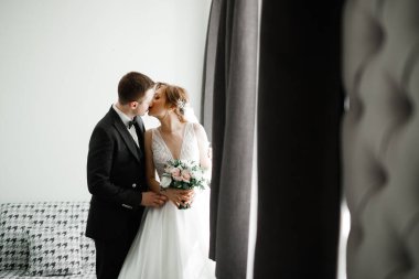 Güzel gelin ve damat düğün günlerinde kucaklaşıp öpüşürler..