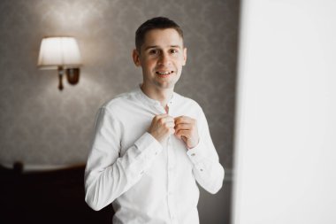 Güzel adam, damat poz veriyor ve düğüne hazırlanıyor..