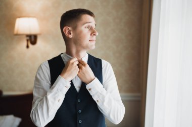 Güzel adam, damat poz veriyor ve düğüne hazırlanıyor..