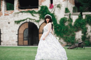 Gelin çiçekli büyük ve güzel bir düğün buketi tutuyor..