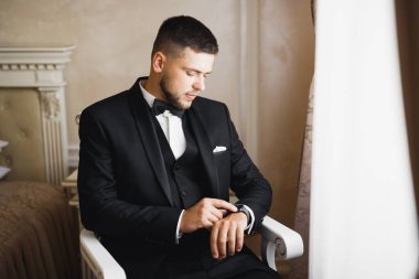 Güzel adam, damat poz veriyor ve düğüne hazırlanıyor..