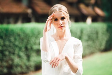 Gelinlik içinde dışarıda poz veren güzel gelin..