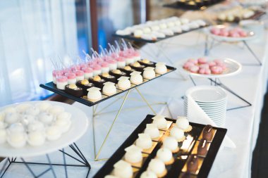 Lezzetli ve tatlı bir tatlı masası. Kapalı resepsiyonda küçük kekler ve shot 'lar var..