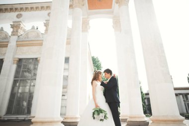 Güzel, mutlu bir düğün çifti, güzel şehirde uzun beyaz elbiseli bir gelin..