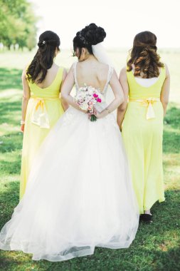 Gelin çiçekli büyük ve güzel bir düğün buketi tutuyor..