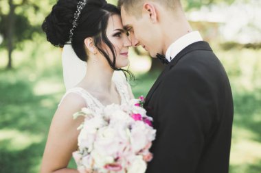 Yeni evli çift el ele tutuşurken parkta koşup zıplıyorlar..