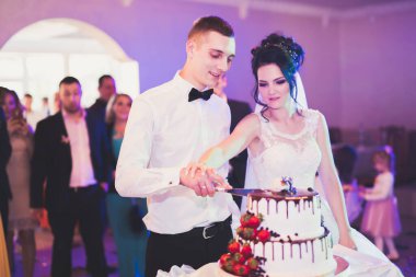 Gelin ve damat düğün pastasını kesiyor..