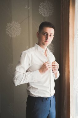 Güzel adam, damat poz veriyor ve düğüne hazırlanıyor..