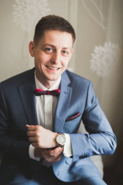 Güzel adam, damat poz veriyor ve düğüne hazırlanıyor..