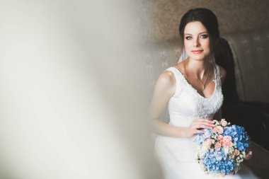 Beyaz elbiseli lüks gelin düğün törenine hazırlanırken poz veriyor..