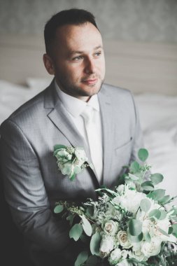 Güzel adam, damat poz veriyor ve düğüne hazırlanıyor..