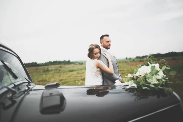 时尚的新婚夫妇 新郎亲吻和拥抱在复古汽车上 — 图库照片