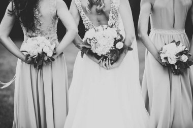 Gelin çiçekli büyük ve güzel bir düğün buketi tutuyor..