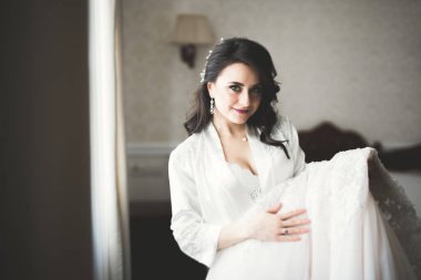 Beyaz elbiseli lüks gelin düğün törenine hazırlanırken poz veriyor..