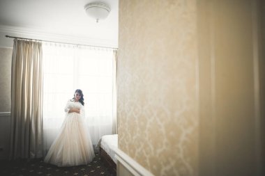 Beyaz elbiseli lüks gelin düğün törenine hazırlanırken poz veriyor..