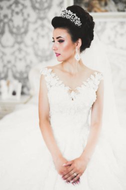 Beyaz elbiseli lüks gelin düğün törenine hazırlanırken poz veriyor..