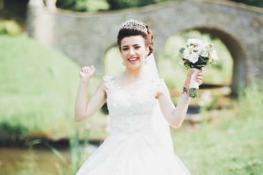 Parkta poz veren gelinlikli güzel, lüks bir gelin..