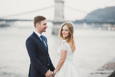 Düğün çifti, damat ve gelin kucaklaşıyor, nehir kenarında..