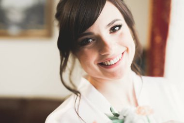 Beyaz elbiseli lüks gelin düğün törenine hazırlanırken poz veriyor..