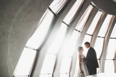 Mükemmel bir çift gelin ve damat düğün günlerinde poz verip öpüşürler..