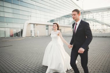 Güzel, mutlu bir düğün çifti, güzel şehirde uzun beyaz elbiseli bir gelin..