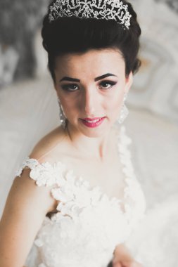 Beyaz elbiseli lüks gelin düğün törenine hazırlanırken poz veriyor..