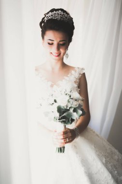 Beyaz elbiseli lüks gelin düğün törenine hazırlanırken poz veriyor..