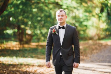 Yaka çiçeğiyle poz veren mutlu yakışıklı damat..