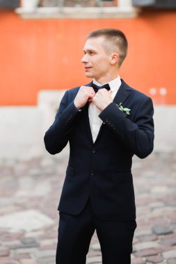 Yaka çiçeğiyle poz veren mutlu yakışıklı damat..