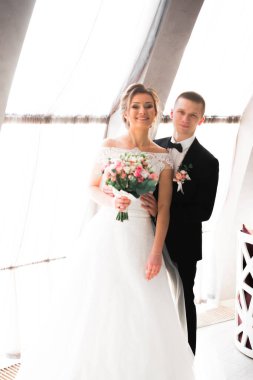 Güzel, genç bir çift ellerinde çiçeklerle poz veriyorlar..